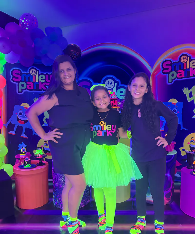 Família reunida em uma festa neon no Smiley Park